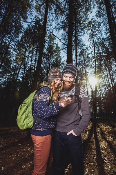 Turistas mirando el teléfono en el bosque — Foto de Stock