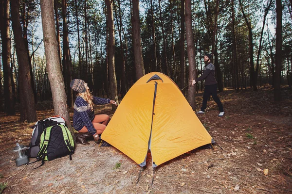 Caminhantes montando uma tenda na madeira — Fotografia de Stock
