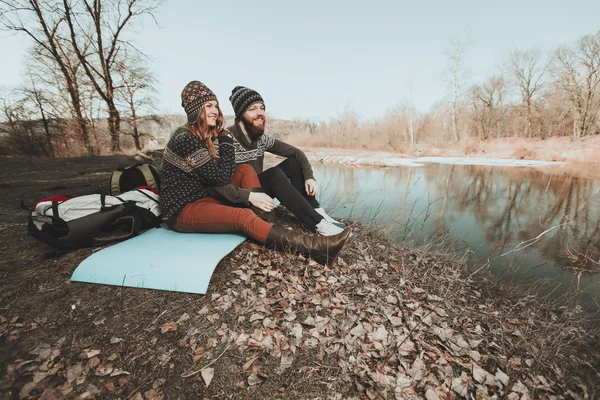 Couple of hikers sitting on the lake shore — Stock Photo, Image