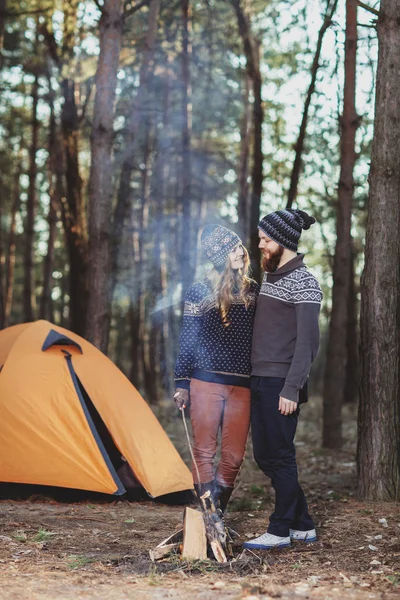 Hikers standing near the fire in the wood — Stock Photo, Image