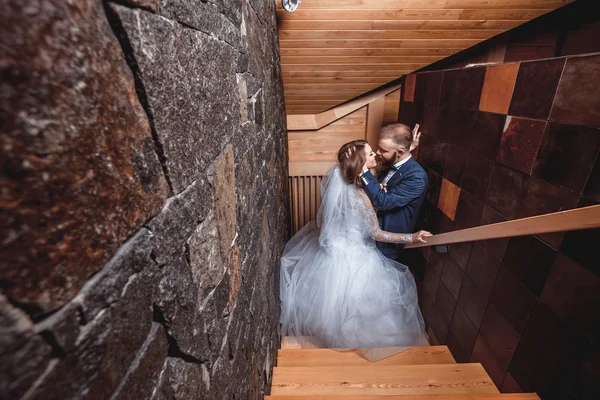 Bride and groom kissing on stairs — Stock Photo, Image