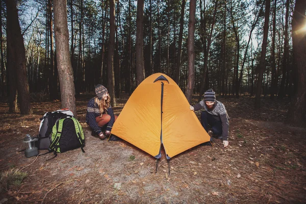 Um par de caminhantes a montar uma tenda na floresta — Fotografia de Stock