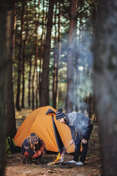 Wanderer stehen am Feuer im Wald — Stockfoto