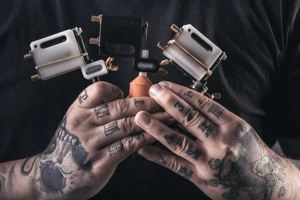 Homme tatoueur avec machines à tatouer — Photo