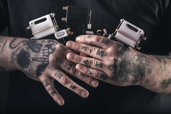 Homme tatoueur avec machines à tatouer — Photo