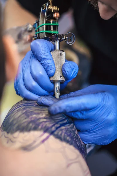 Татуировщик делает татуировку — стоковое фото
