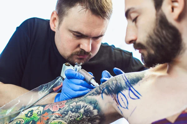 Tatovør gør en tatovering - Stock-foto