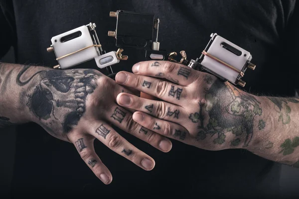 Hombre tatuaje artista con máquinas de tatuaje Imagen De Stock