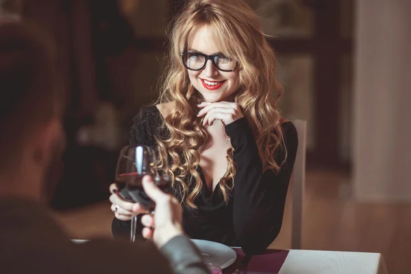 Belo jovem casal com copos de vinho tinto em restaurante de luxo — Fotografia de Stock