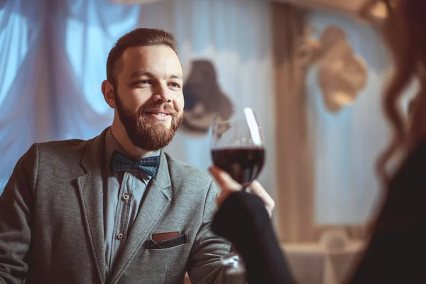 Hermosa pareja joven con copas de vino tinto en un restaurante de lujo —  Fotos de Stock