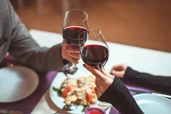 Beau jeune couple avec des verres de vin rouge dans un restaurant de luxe — Photo
