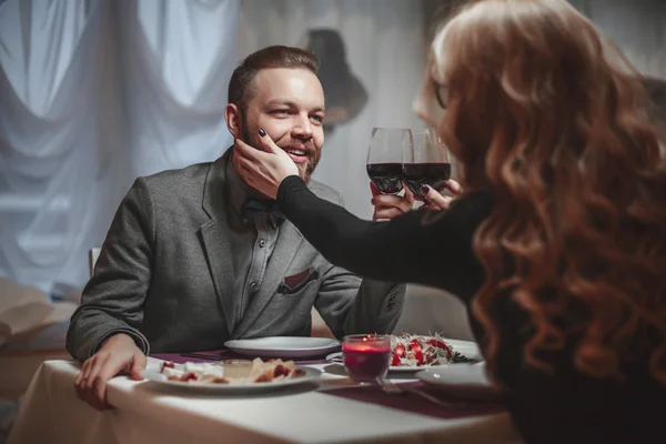 Belo jovem casal com copos de vinho tinto em restaurante de luxo — Fotografia de Stock