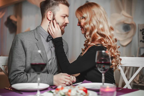 Belo jovem casal com copos de vinho tinto em restaurante de luxo — Fotografia de Stock