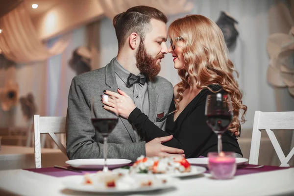 Mooie jonge paar met glazen rode wijn in luxe restaurant — Stockfoto