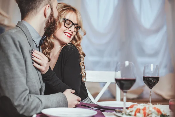 Hermosa pareja joven con copas de vino tinto en un restaurante de lujo —  Fotos de Stock