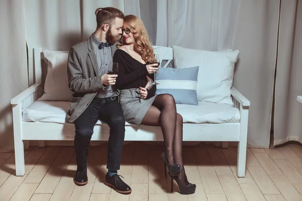 Bonito jovem casal amoroso sentado em um banco — Fotografia de Stock