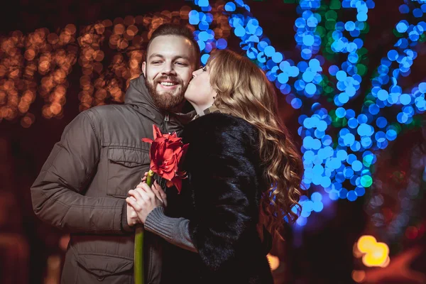 Lief jong koppel buiten lopen in de winter. Meisje met een bloem — Stockfoto