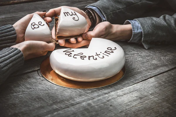 Прекрасный торт на День Святого Валентина в руках любящей пары — стоковое фото