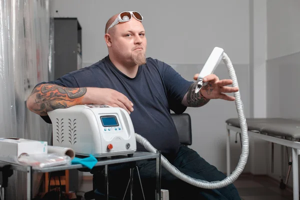 The professional machine for removal of tattoos with master — Stock Photo, Image