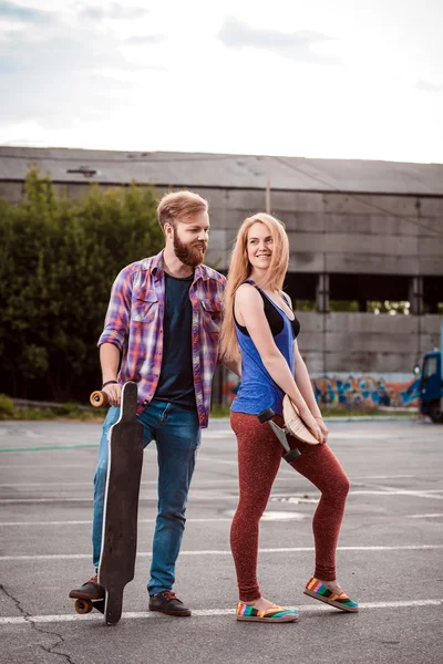 젊은 부부 밖에 스케이트 보드를 들고 있다 — 스톡 사진