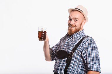 Deri pantolon ile mutlu gülümseyen adam oktoberfest bira cam tutar. Beyaz arka plan üzerinde izole