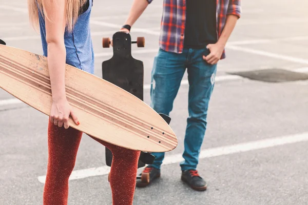 Casal jovem está segurando skate fora — Fotografia de Stock