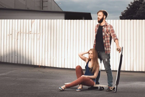 Young couple are holding skateboard outside — Stock Photo, Image