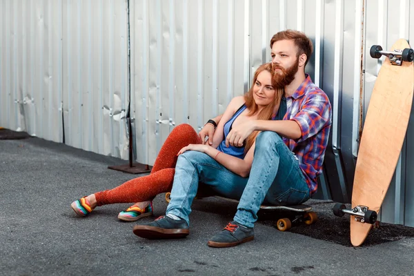 Casal jovem está segurando skate fora — Fotografia de Stock