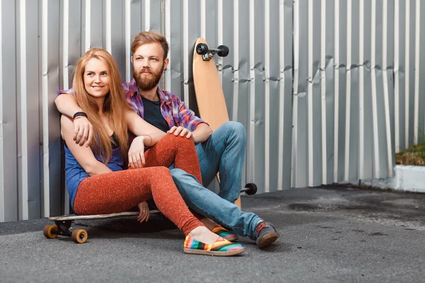 Casal jovem está segurando skate fora — Fotografia de Stock