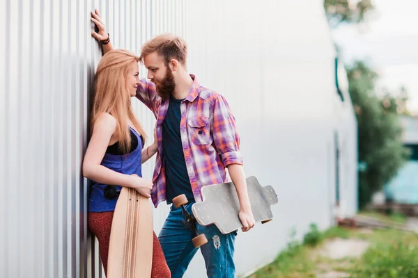 Casal jovem está segurando skate fora — Fotografia de Stock