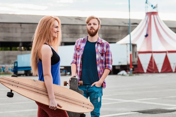 Casal jovem está segurando skate fora — Fotografia de Stock