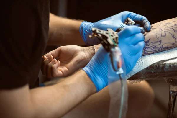 O tatuador faz uma tatuagem. Fechar. — Fotografia de Stock