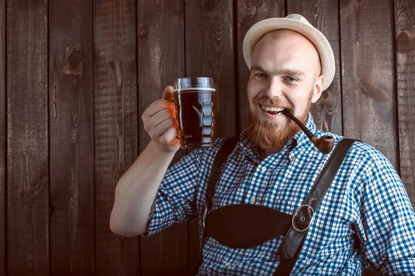 Щасливий усміхнений чоловік зі шкіряними штанами, дегустація свіжого пива . — стокове фото