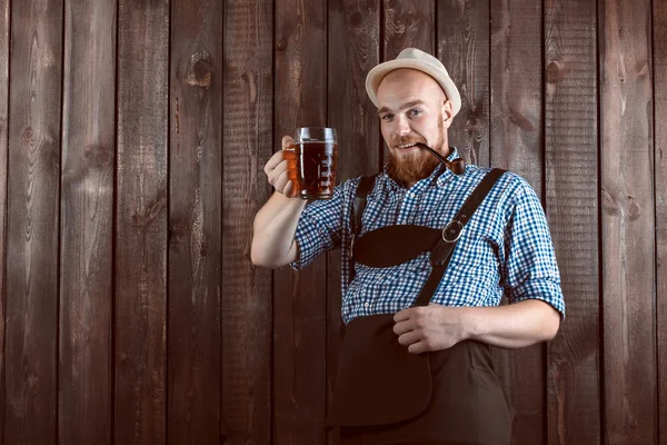 快乐的男人微笑着与皮革长裤 (lederhose) 持有慕尼黑啤酒节啤酒玻璃 — 图库照片