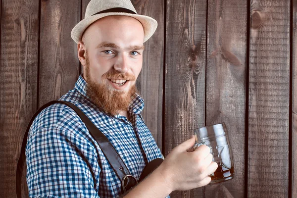 Щасливий усміхнений чоловік зі шкіряними штанами тримає пивний келих — стокове фото