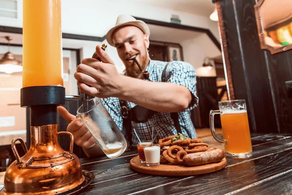 Oktoberfest bira cam deri pantolon (lederhose) ile mutlu gülümseyen adam tutar