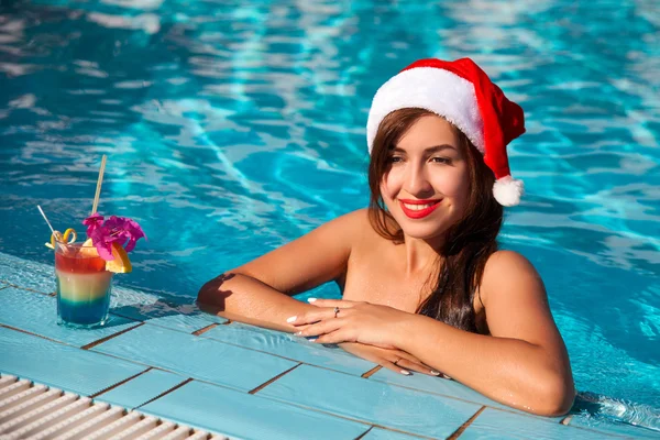 Mujer de Navidad hermosa sonriendo en el sombrero de Santa — Foto de Stock