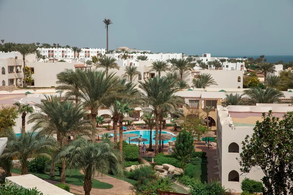 Palmiye ağaçları ve mavi gökyüzü ile lüks Mısır otel — Stok fotoğraf