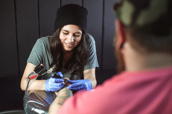 Vacker brunett flicka gör tatuering — Stockfoto