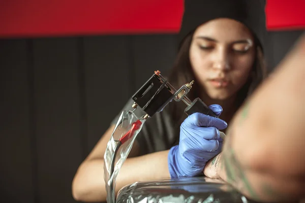 Piękna brunetka dziewczyna sprawia, że tatuaż. Tattooist sprawia, że tatuaż. Zbliżenie — Zdjęcie stockowe