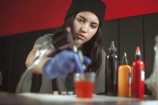 Schöne brünette Mädchen macht Tätowierung. Tätowierer tätowiert. Nahaufnahme — Stockfoto