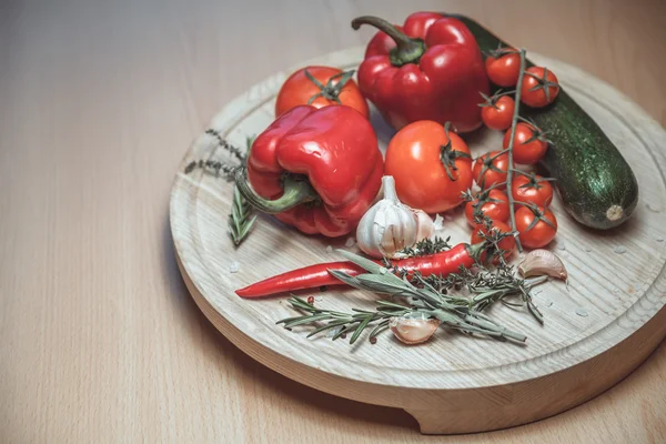 Verse groenten. Bovenaanzicht van rode rijpe tomaten en komkommer op houten tafel. — Stockfoto