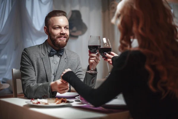 Belo jovem casal com copos de vinho tinto em restaurante de luxo — Fotografia de Stock