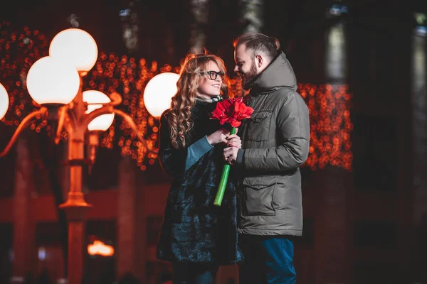 Lief jong koppel buiten lopen in de winter. Meisje met een bloem — Stockfoto