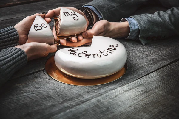 Hermoso pastel con las palabras Be My Valentine para el día de San Valentín en las manos de una pareja amorosa — Foto de Stock