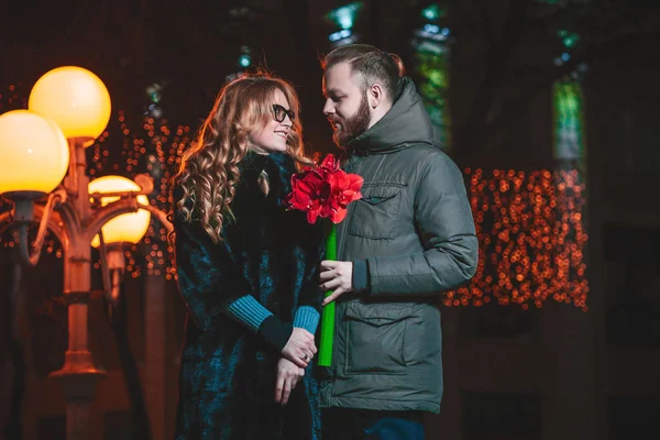 Amour jeune couple marchant à l'extérieur en hiver. Fille tenant une fleur — Photo