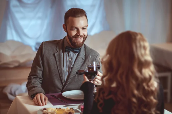 Mooie jonge paar met glazen rode wijn in luxe restaurant — Stockfoto