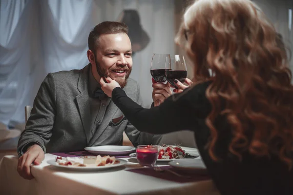 Belo jovem casal com copos de vinho tinto em restaurante de luxo — Fotografia de Stock