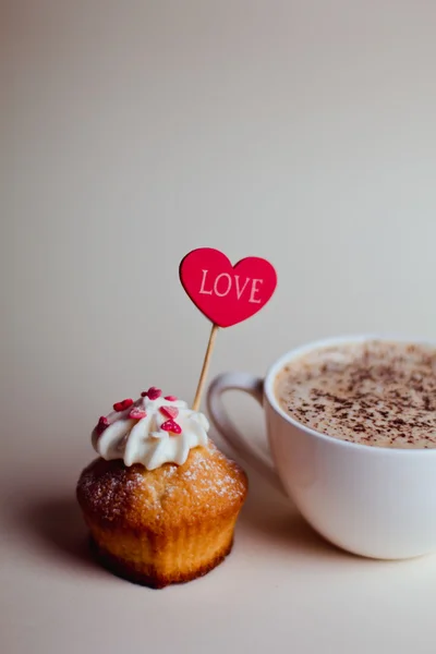 Beyaz ahşap zemin üzerinde kalp kek ile güzel kahve fincanı — Stok fotoğraf