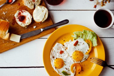 Beyaz ahşap masa üzerinde sağlıklı kahvaltı için iki kızarmış yumurta